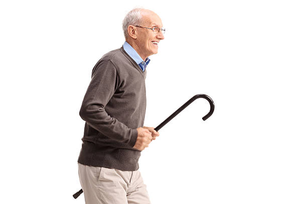 istock Joyful senior gentleman carrying a cane and running 483807218
