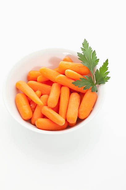 istock Baby carrot in bowl on white background 483807390