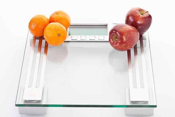 istock Apples and clementines on scales,close up 483807758