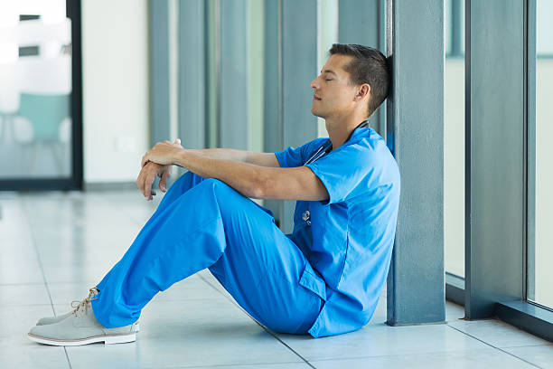 istock young doctor sitting on the floor 483808720