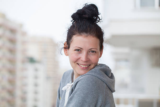 porträt einer schönen jungen frau auf dem balkon, leger - beauty in nature women beautiful human teeth stock-fotos und bilder