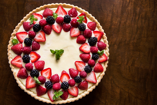 A overhead view of a homemade lemon curd and fruit tart.