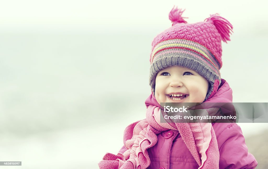 Feliz niña bebé en un sombrero rosa y bufanda - Foto de stock de Invierno libre de derechos