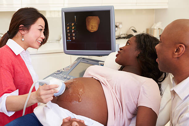 mujer embarazada y pareja con ecografía 4d - ultrasound human pregnancy ultrasound machine doctor fotografías e imágenes de stock