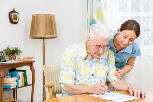 istock Caregiver and senior man writing paper 483815879