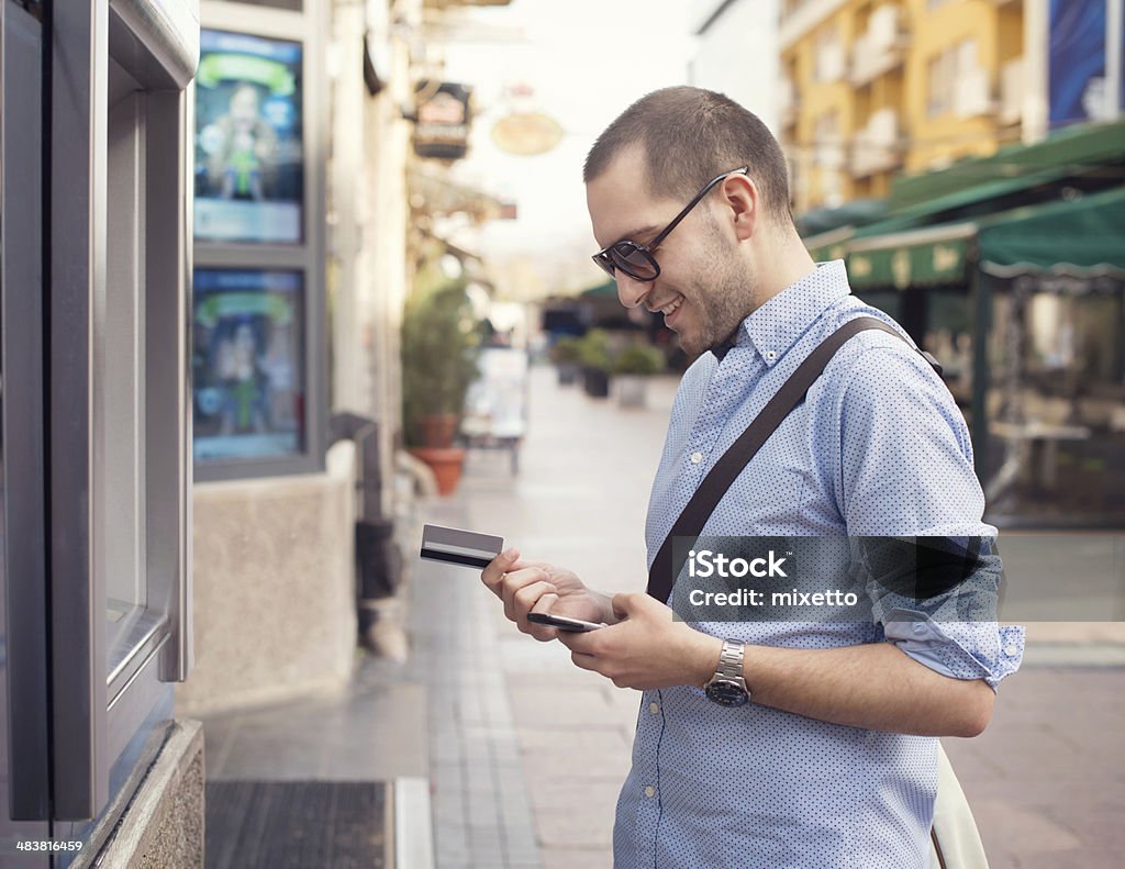 Young man withdrawing money from credit card at ATM. ATM Stock Photo