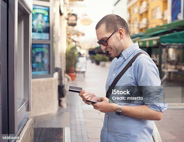 Young Man Withdrawing Money From Credit Card At Atm Stock Photo - Download Image Now