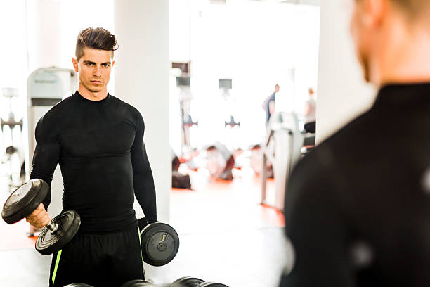 istock Muscular man working out in a gym and lifting weights 483816554