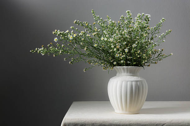 istock Still life with flowers in white vase on table 483817574