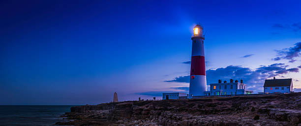 istock Lighthouse shining over ocean shore sunset Portland Bill Dorset UK 483817720