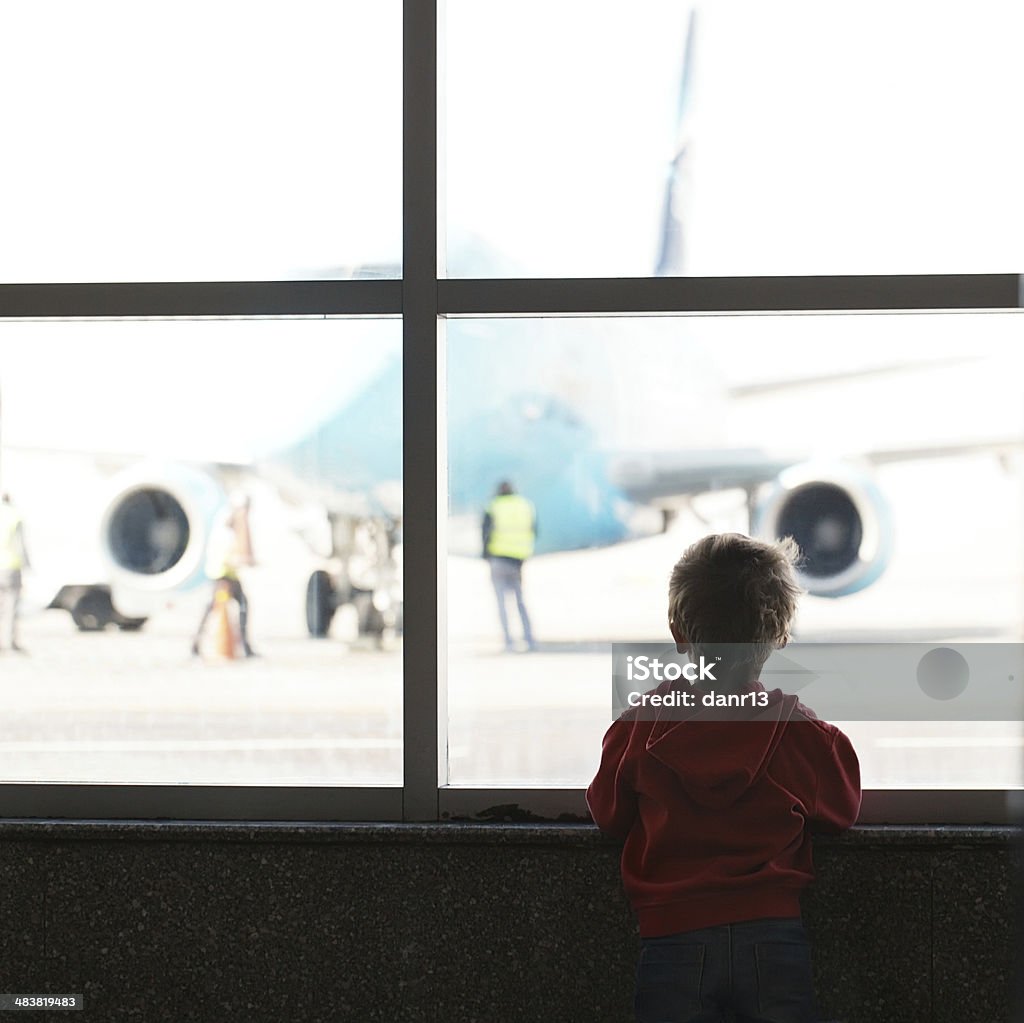 Boy looks at the plane Boy looks at the plane at the airport silhouette shot from back 12-17 Months Stock Photo