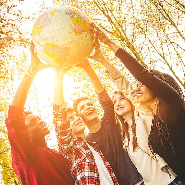 istock Group of teenagers holding an earth globe 483819559