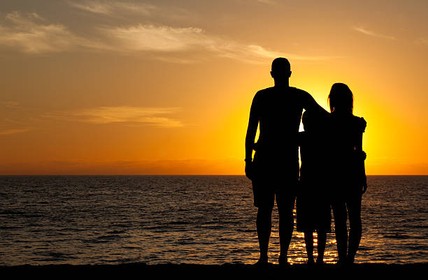 jovem família na praia ao pôr-do-sol - standing family golf loving - fotografias e filmes do acervo