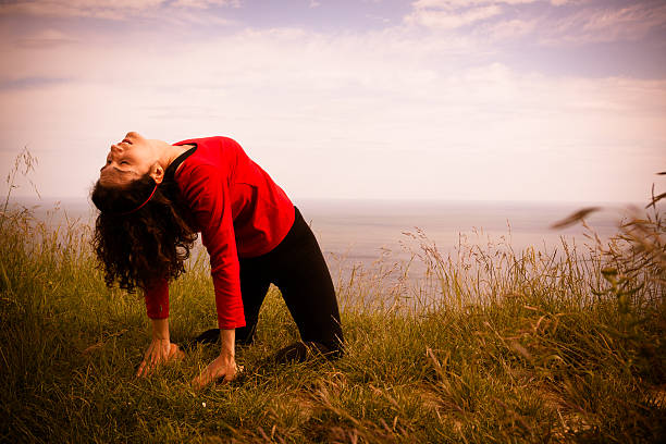 Middle age woman doing yoga exercise outdoors stock photo