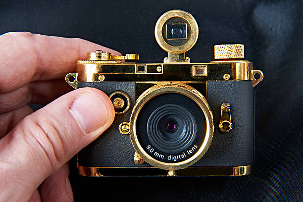 istock Mini gift golden camera in big hand 483820173