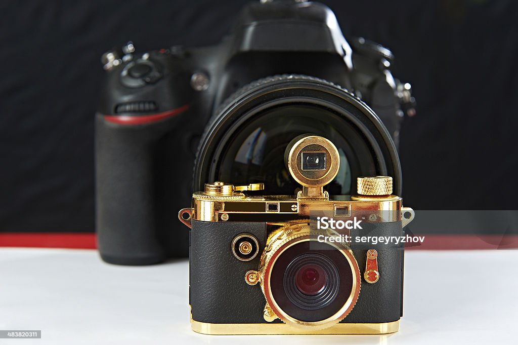 Mini prezent golden kamery na tło z big jeden - Zbiór zdjęć royalty-free (Aparat cyfrowy)