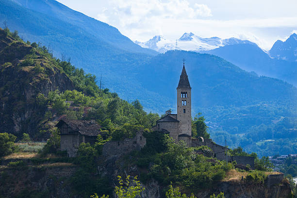 Church of Villeneuve against snow covered mountains, Aosta Valley, Italy stock photo