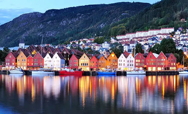 Colorful city of Bergen in Norway at night. Bergen is a perfect launch point for exploring western Norway's stunning fjords and glaciers, including Hardangerfjord and Sognefjord. The colorful Norwegian city of Bergen is also a gateway to majestic fjords. Bryggen Hanseatic Wharf will give you a sense of the local culture.