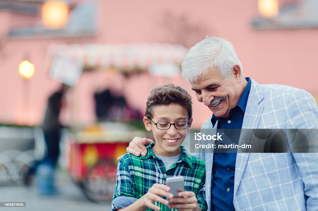 Vater und Sohn SMS auf smartphone im Freien - Lizenzfrei Familie Stock-Foto