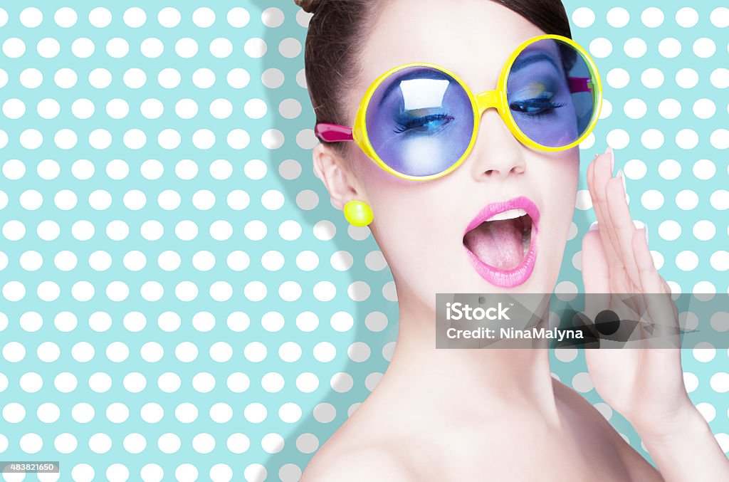Attractive surprised young woman wearing sunglasses Attractive surprised young woman wearing sunglasses on dotted background, beauty and fashion concept  Sunglasses Stock Photo