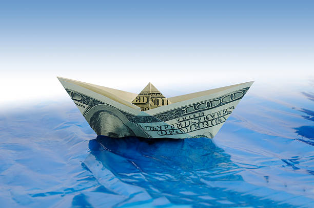 Dollar Ship Paper dollar ship on water making money origami stock pictures, royalty-free photos & images