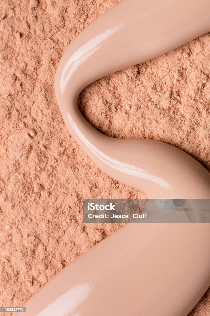 Foudation powder with liquid foundation Close up of light colored foundation powder with a spill of liquid foundation 2015 Stock Photo