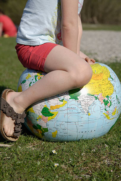 istock Girl sitting on earth beach ball 483830072
