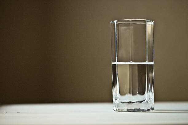 Half empty or half full? No matter how you say it, you've got to take a side. Either the focus will be what's in the glass or what's not in the glass.  pessimism photos stock pictures, royalty-free photos & images