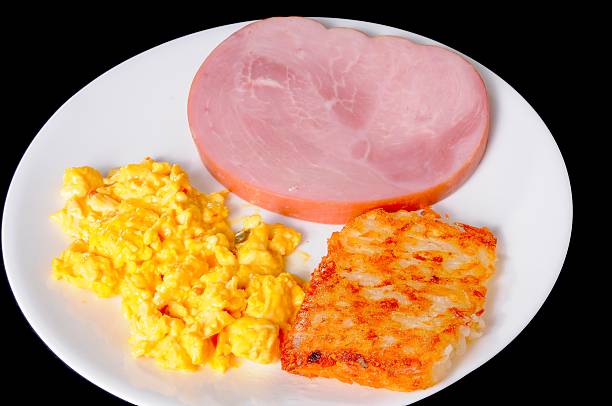 Breakfast plate of ham steak hash brown potatos and mexican omlette