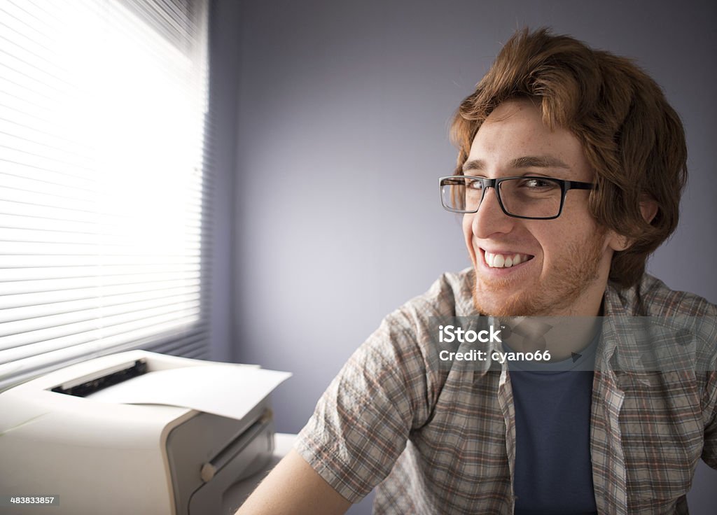 Nerd guy smiling Funny nerd guy with glasses smiling, office on background. Computer Printer Stock Photo