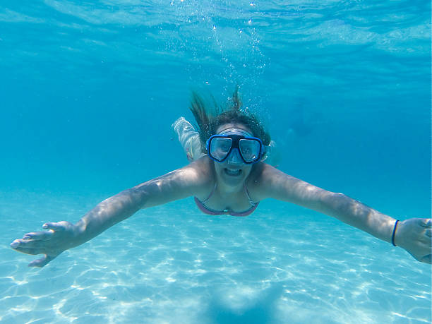 istock Girl in bikini swimming underwater in blue pool 483834186
