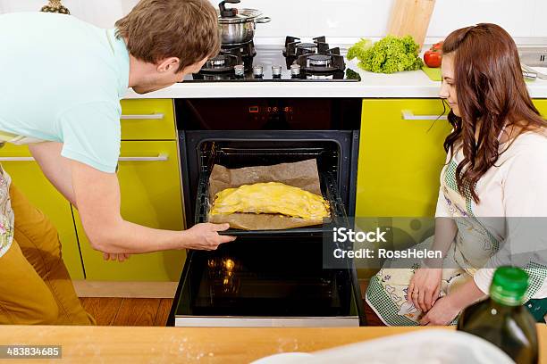 Casal Casado Colocando Maçã No Forno Na Cozinha - Fotografias de stock e mais imagens de Adulto - Adulto, Amor, Avental