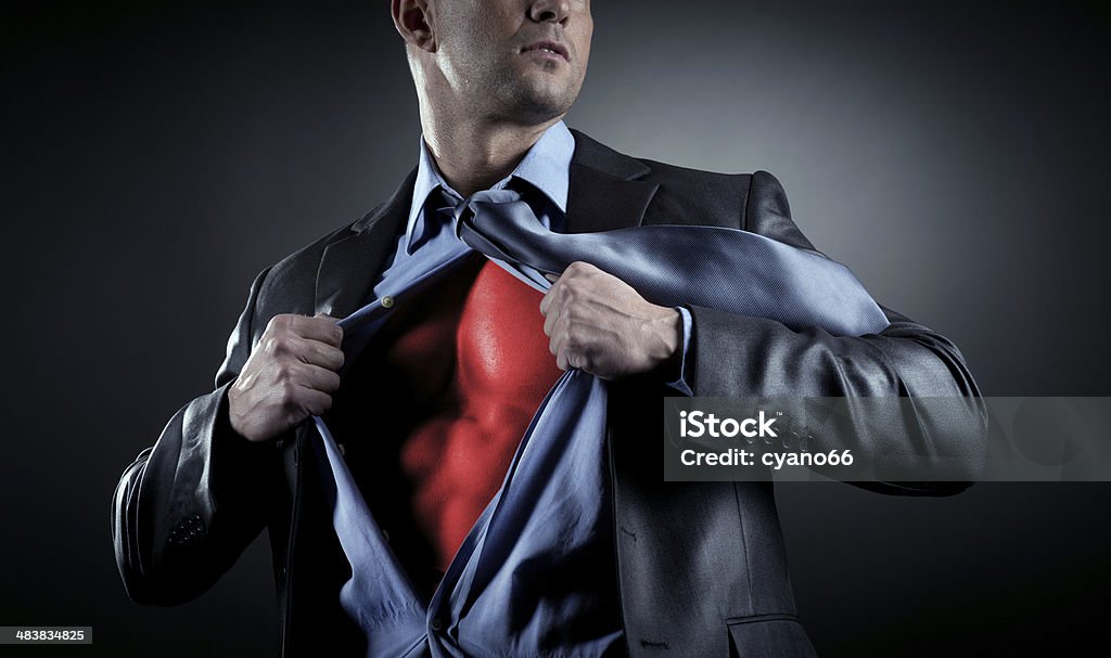 Succesful businessman Attractive male businessman stripping off shirt and showing his muscular chest. Superhero Stock Photo