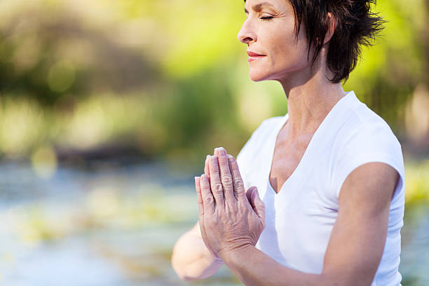 istock middle age woman doing yoga meditation 483834879