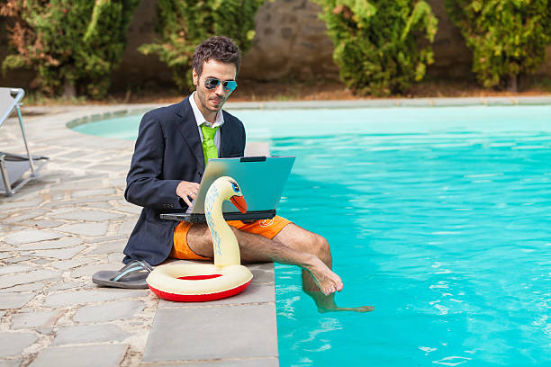 divertente giovane imprenditore con swimmingtrunks accanto alla piscina - travel people traveling business travel vacations foto e immagini stock
