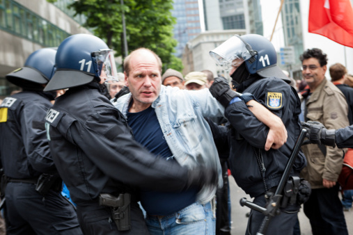 Frankfurt, Germany - June 1, 2013: A male protestor is trying to break through the riot police cordon - and getting into a fight at Blockupy 2013 demonstration in the city center of Frankfurt. Blockupy is a left-wing political network of several organizations. The name derives from its plan for a \