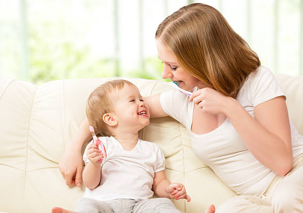 mutter und tochter baby mädchen putzen ihrer zähne zusammen - child brushing human teeth brushing teeth stock-fotos und bilder