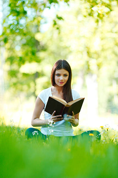 istock Woman reading book outdoors 483837141