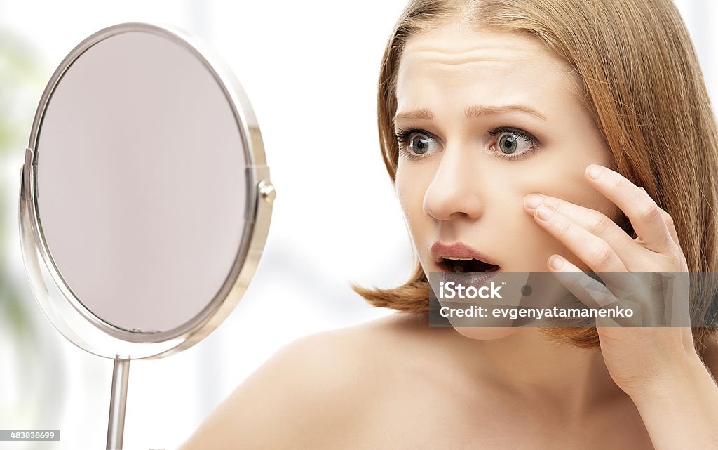 beautiful healthy woman  saw in the mirror acne and wrinkles young beautiful healthy woman  frightened saw in the mirror acne and wrinkles Shock Stock Photo