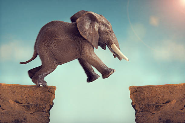 leap of faith concept elephant jumping across a crevasse leap of faith concept elephant jumping across a crevasse leap of faith stock pictures, royalty-free photos & images