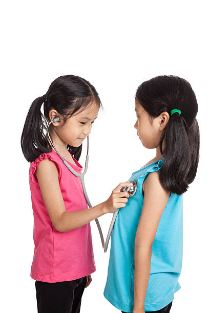 Little girl tries to listen to her own heartbeat with a stethescope on a white background