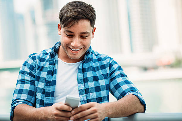 istock Casual man with phone texting outdoors 483850114