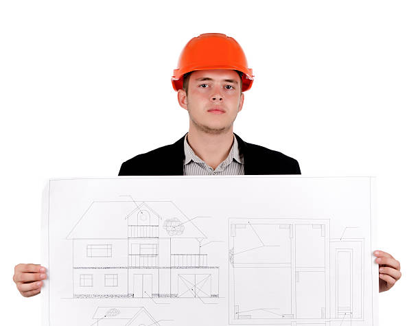 istock Young Engineer in Orange Helmet Showing Blueprint 483851760