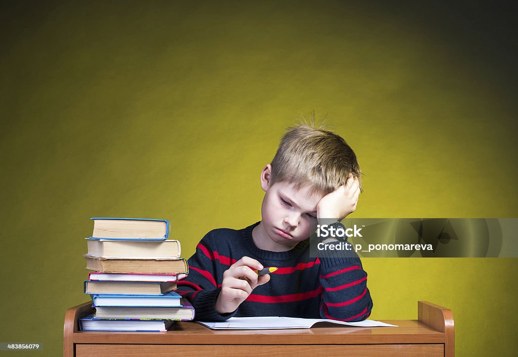 Child with learning difficulties. Tired boy doing homework. Child Stock Photo