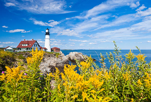 Portland Head Lighthouse In Maine, USA The Portland Head Lighthouse In Maine, USA With Yellow Flowers In The Foreground lighthouse maine new england coastline stock pictures, royalty-free photos & images