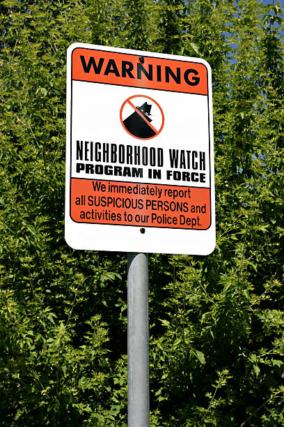 neighborhood watch sign in the neighborhood to serve as a deterrent in advising of a neighborhood watch program being in place neighborhood crime watch stock pictures, royalty-free photos & images