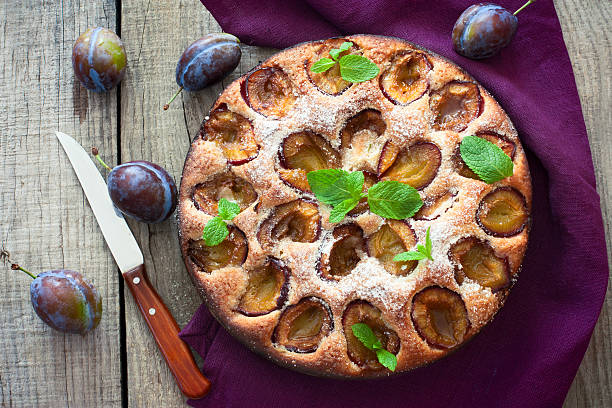 istock Plum cake over natural wood background 483858232