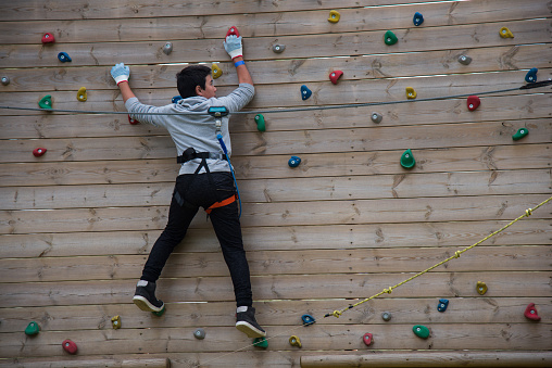 Young boy climbing on climbing wall
