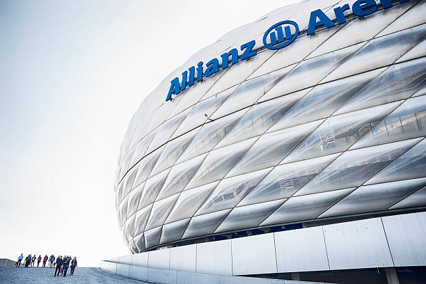 Allianz Arena Munich, Germany Munich, Germany - March 28, 2014: Allianz Arena is a football stadium in Munich , Bavaria. FC Bayern Munich and TSV 1860 Munich , two professional football clubs , have played their home games there at May 2005. People are walking and watching at the stadium. allianz arena stock pictures, royalty-free photos & images