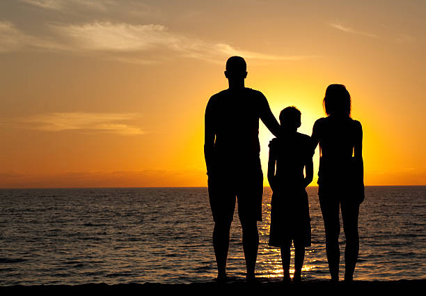 jovem família na praia ao pôr-do-sol - standing family golf loving - fotografias e filmes do acervo